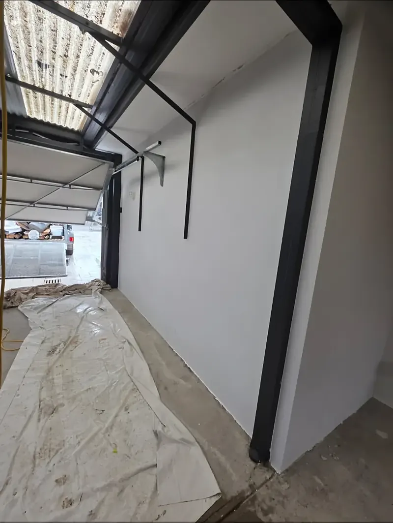 After: the carport wall rendered, beside the steel posts
